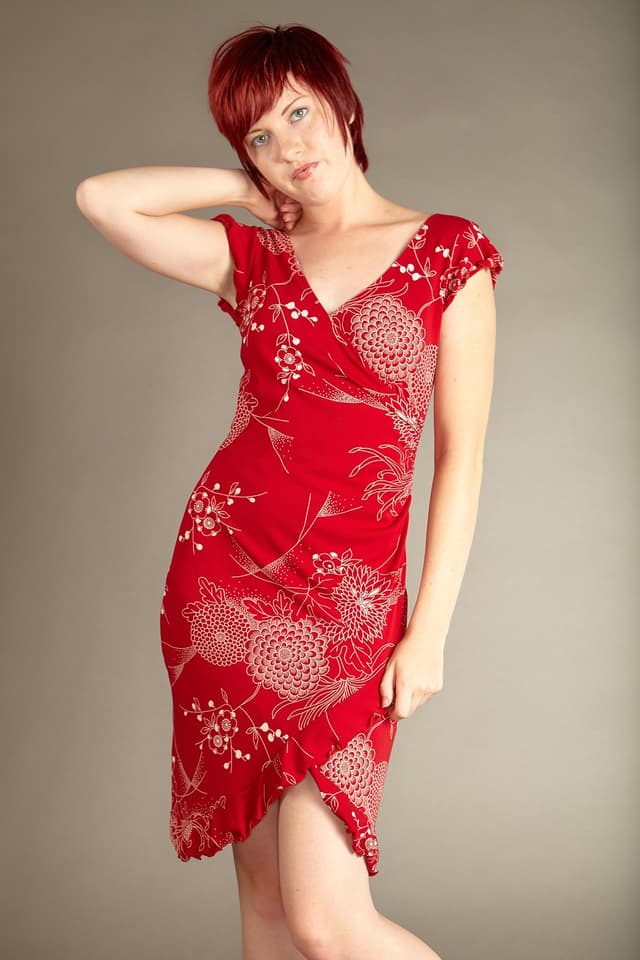 Woman in a crimson floral wrap dress
