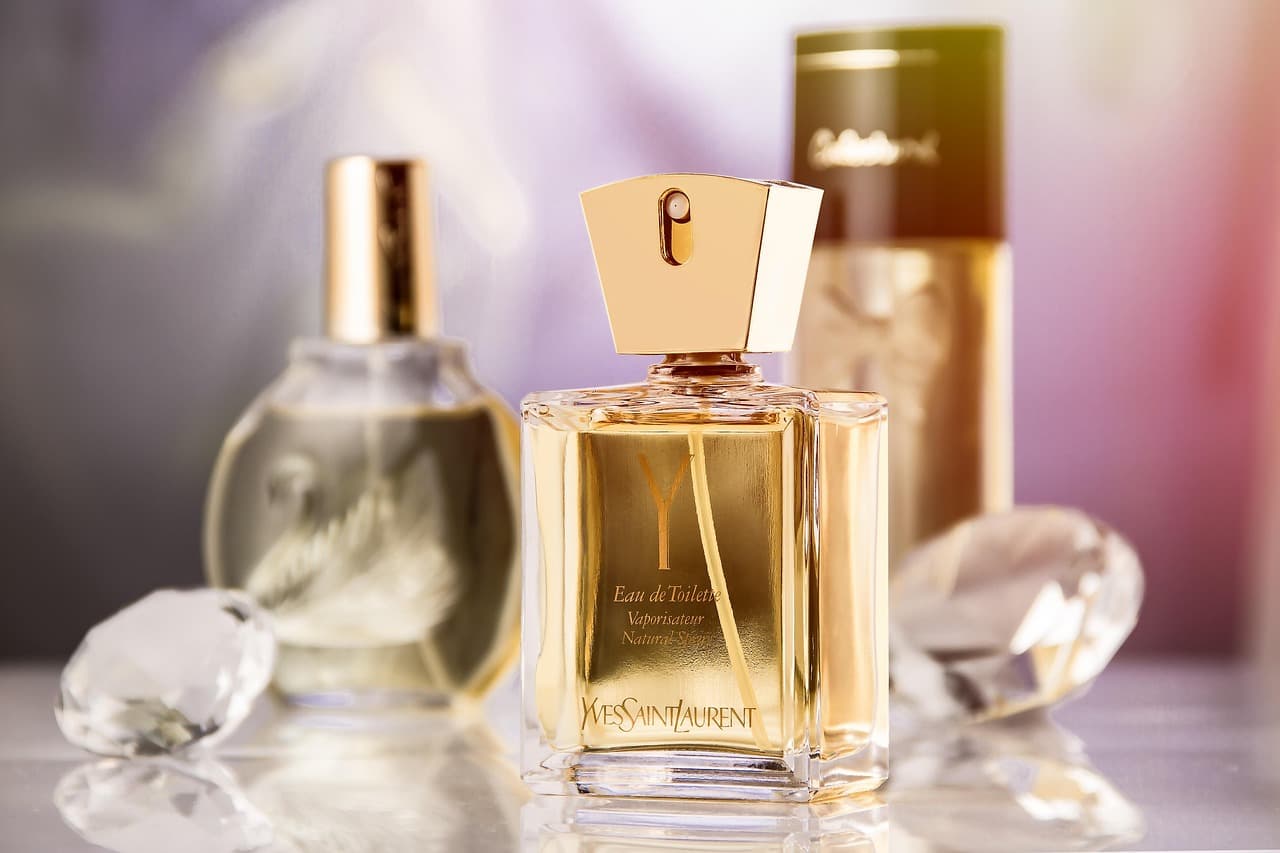 Amber glass perfume bottles on a warm neutral surface